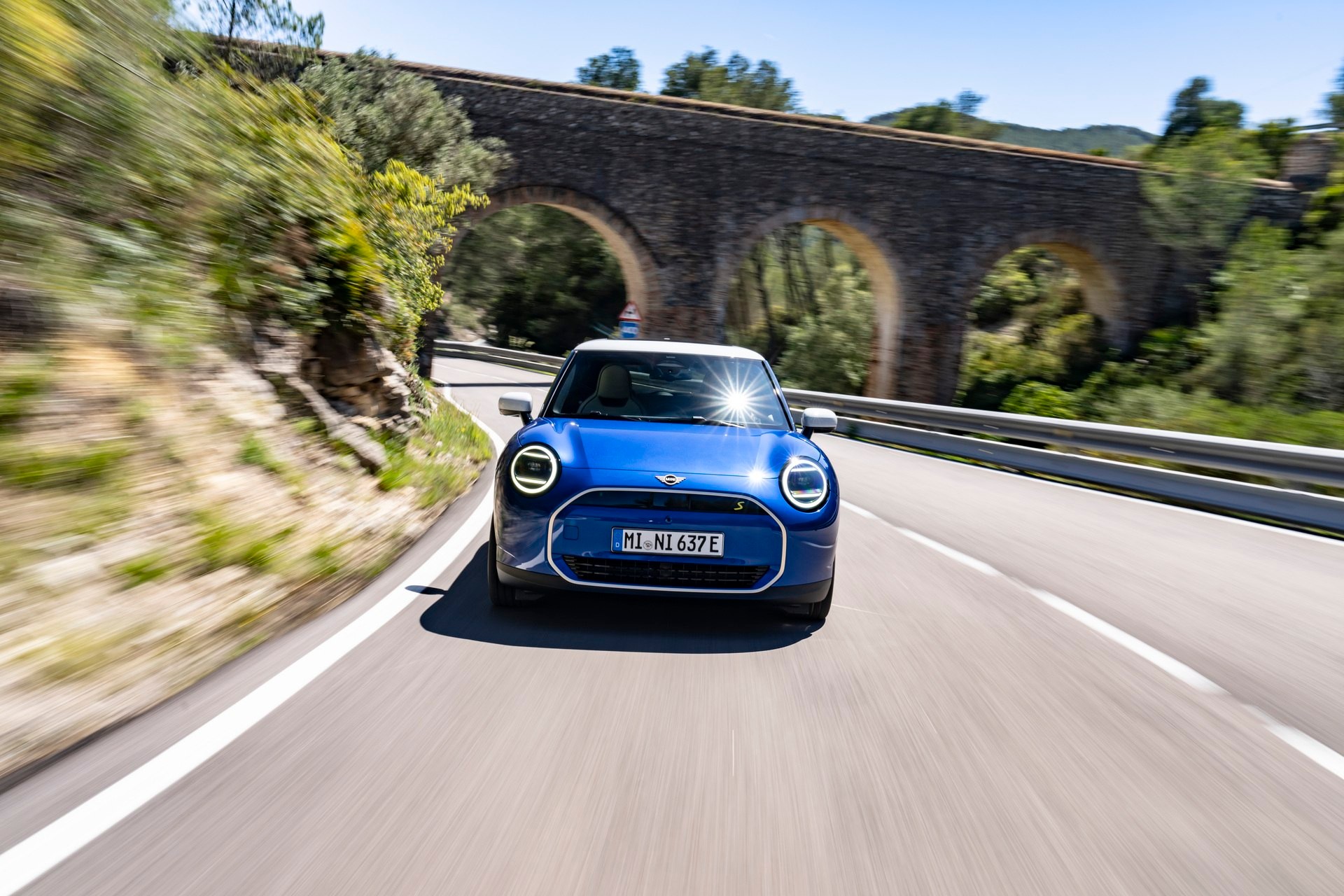 MINI Cooper SE visto de frente a circular na estrada, 2024.